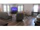 Open concept living room with ample seating, entertainment unit and wood flooring at 5949 Se 164Th Ct, Ocklawaha, FL 32179