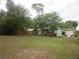 Large lot with a home, 2 garages, established trees and landscaping surrounded by a red fence at 5949 Se 164Th Ct, Ocklawaha, FL 32179