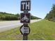 Trailhead sign with an ATV symbol and an arrow pointing left, indicating the trail entrance at 5949 Se 164Th Ct, Ocklawaha, FL 32179
