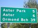 Green road sign indicating distances to Astor Park, Astor, and Ormond Beach for easy navigation at 5949 Se 164Th Ct, Ocklawaha, FL 32179