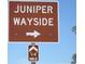 Brown 'Juniper Wayside' sign with a white arrow indicating direction, located one-quarter mile away at 5949 Se 164Th Ct, Ocklawaha, FL 32179