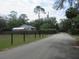 Street view featuring a house, bordered by trees, grass and a fence at 5949 Se 164Th Ct, Ocklawaha, FL 32179