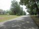 Street view with trees and green space, and houses in the background at 5949 Se 164Th Ct, Ocklawaha, FL 32179
