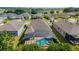 Aerial view of home with screened-in pool, landscaped yard, and surrounding neighborhood with a lake at 6394 Sw 97Th Terrace Rd, Ocala, FL 34481