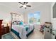 Comfortable bedroom featuring a ceiling fan, a rocking chair, and a window providing natural light at 6394 Sw 97Th Terrace Rd, Ocala, FL 34481