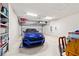 A clean garage with a sleek blue car parked inside at 6394 Sw 97Th Terrace Rd, Ocala, FL 34481
