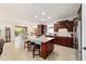 Open kitchen layout with granite island, wood cabinetry, stainless steel appliances, and access to outdoor seating at 6394 Sw 97Th Terrace Rd, Ocala, FL 34481