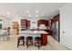 Bright kitchen with granite island, stainless steel appliances, wood cabinets, and tile flooring at 6394 Sw 97Th Terrace Rd, Ocala, FL 34481