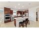 Well-lit kitchen with stainless steel appliances, wood cabinets, granite countertop island and tile flooring at 6394 Sw 97Th Terrace Rd, Ocala, FL 34481