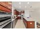 Spacious kitchen with stainless steel appliances, tile flooring, granite countertops, wood cabinets, and modern lighting at 6394 Sw 97Th Terrace Rd, Ocala, FL 34481