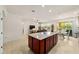 Open kitchen area with granite island, stainless steel appliances, and tile flooring overlooking the living space at 6394 Sw 97Th Terrace Rd, Ocala, FL 34481