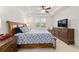 Main bedroom featuring tray ceiling, a ceiling fan, a window with blinds, and a rocking chair at 6394 Sw 97Th Terrace Rd, Ocala, FL 34481