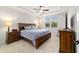 Bedroom featuring tray ceiling, a ceiling fan, a window with blinds, and bedside tables at 6394 Sw 97Th Terrace Rd, Ocala, FL 34481