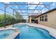 A spacious pool with a connected spa is surrounded by a screened enclosure at 6394 Sw 97Th Terrace Rd, Ocala, FL 34481