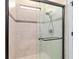 Walk-in shower with decorative tile, shower head and glass sliding door at 6394 Sw 97Th Terrace Rd, Ocala, FL 34481