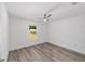 Simple bedroom with wood-look floors, a ceiling fan, and window view at 6689 Nw 61St St, Ocala, FL 34482
