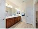 Charming bathroom featuring a dual sink vanity, modern fixtures, and wood-look tile flooring at 6868 Sw 95Th Cir, Ocala, FL 34481