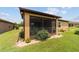 Outdoor view of screened patio with garden, brick paver trim, and tan exterior at 6868 Sw 95Th Cir, Ocala, FL 34481