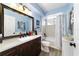 Charming bathroom featuring a tiled shower, spacious vanity, and wood flooring at 8140 Sw 109Th Street Rd, Ocala, FL 34481