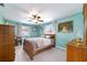 This cozy bedroom features neutral walls, a ceiling fan, natural lighting, and a comfortable bed at 8140 Sw 109Th Street Rd, Ocala, FL 34481