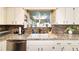 Kitchen sink with granite counters, white cabinets and view to the backyard at 8140 Sw 109Th Street Rd, Ocala, FL 34481