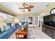 Bright living area with ceiling fan, large windows, comfortable seating, and a charming fireplace at 8140 Sw 109Th Street Rd, Ocala, FL 34481