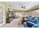 Comfortable sunroom featuring large windows, casual seating, ceiling fan, and a TV entertainment center at 8140 Sw 109Th Street Rd, Ocala, FL 34481