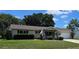 Inviting single-story home featuring a well-kept lawn, an American flag, and a cozy front porch at 8244 Sw 106Th Pl, Ocala, FL 34481