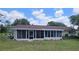 Exterior view of the sun room with plenty of windows, neutral siding, and well-maintained lawn at 8244 Sw 106Th Pl, Ocala, FL 34481