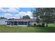 Exterior view featuring sunroom, well-maintained yard, and mature trees at 8244 Sw 106Th Pl, Ocala, FL 34481