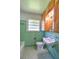 Retro bathroom featuring turquoise tiling, a sink, and a toilet at 834 Ne 10Th Ave, Ocala, FL 34470
