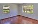 An empty bedroom with two windows and hardwood floors at 834 Ne 10Th Ave, Ocala, FL 34470