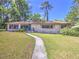 Charming single-story home with a well-manicured lawn, mature trees, and a walkway leading to the entrance at 834 Ne 10Th Ave, Ocala, FL 34470
