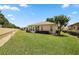 Well-maintained backyard featuring lush green grass, manicured bushes, and a home's screened-in patio at 8617 Se 141St Street Rd, Summerfield, FL 34491
