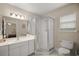 Bright bathroom featuring a glass-enclosed shower, white tile flooring and a large mirror at 8617 Se 141St Street Rd, Summerfield, FL 34491