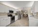 Spacious kitchen with stainless steel appliances, white cabinetry, and seamless flow into the dining room at 8617 Se 141St Street Rd, Summerfield, FL 34491