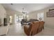 Cozy living room with comfortable leather seating, ceiling fan, and plantation shutters at 8617 Se 141St Street Rd, Summerfield, FL 34491