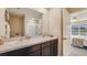 Bathroom featuring double sinks, granite countertops, and a view of the pond at 8653 Sw 44Th Ter, Ocala, FL 34476