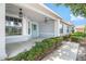 Inviting front porch with decorative hanging lights and freshly trimmed shrubs adds to the home's curb appeal at 9287 Sw 91St Court Rd, Ocala, FL 34481