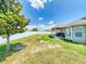 Wide backyard has a white fence, grass lawn, covered patio with table and chairs, and the back of the house at 9677 Sw 56Th Cir, Ocala, FL 34476