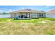 The backyard with vinyl fencing has a covered patio with furniture, a lawn, and solar panels on the roof at 9677 Sw 56Th Cir, Ocala, FL 34476