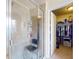 The bathroom features a glass shower with a seat and shelving, and an adjacent walk-in closet for convenience at 9677 Sw 56Th Cir, Ocala, FL 34476