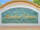 Close-up of the Meadow Glenn community sign with gold lettering and a green tiled background at 9677 Sw 56Th Cir, Ocala, FL 34476