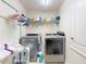Convenient laundry room featuring modern washer and dryer units with storage shelves at 9677 Sw 56Th Cir, Ocala, FL 34476