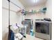 Functional laundry room includes washer, dryer, shelving, and a hanging rack for convenience at 9677 Sw 56Th Cir, Ocala, FL 34476