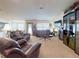 Comfortable living room with carpet, leather sofas, and natural light from large windows at 9677 Sw 56Th Cir, Ocala, FL 34476