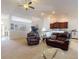 Inviting living room with plush seating, ceiling fan, and open floor plan flows into kitchen at 9677 Sw 56Th Cir, Ocala, FL 34476