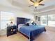 Spacious main bedroom featuring a tray ceiling, ceiling fan, and large windows for lots of natural light at 9677 Sw 56Th Cir, Ocala, FL 34476