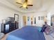 Bright and airy main bedroom featuring a tray ceiling, ceiling fan, and plenty of space at 9677 Sw 56Th Cir, Ocala, FL 34476