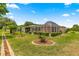 Backyard featuring a screened lanai, lush lawn, and decorative landscaping at 9958 Sw 59Th Cir, Ocala, FL 34476